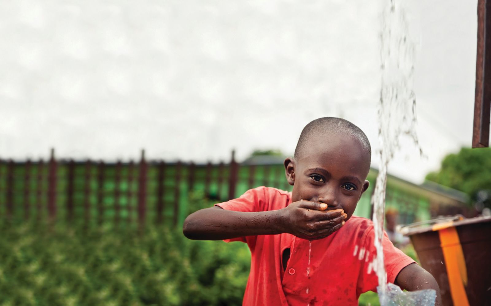 Children hand pump fresh, clean water.