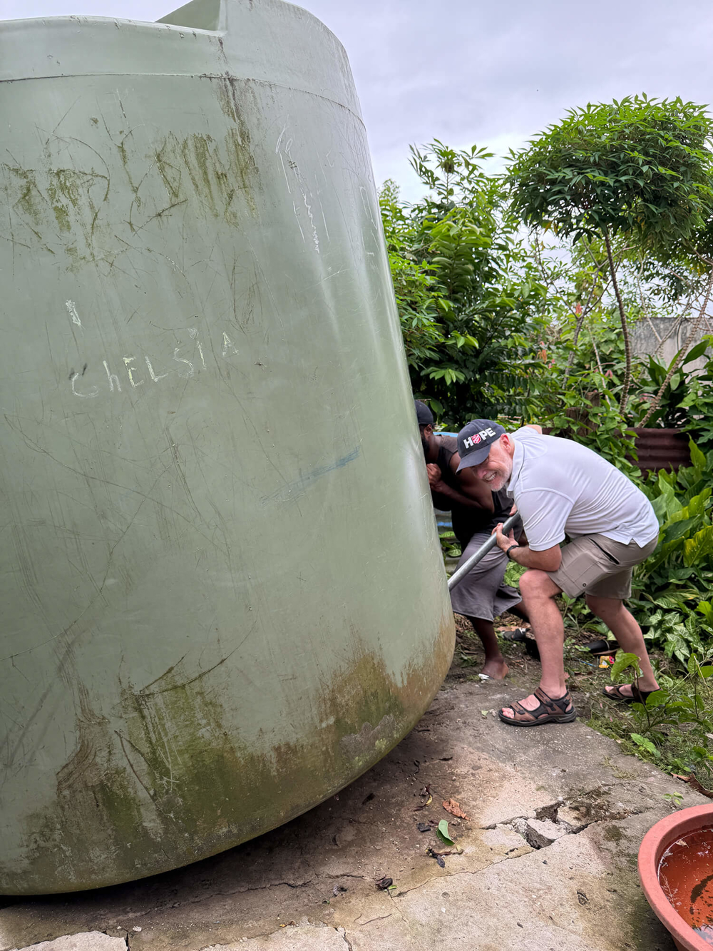 Darren Elsley and a local volunteer reseating a water tank