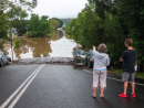 A couple staring at flood water and surrounding damage