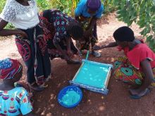 Judith and the group pouring soap into moulds which are later cut and sold.