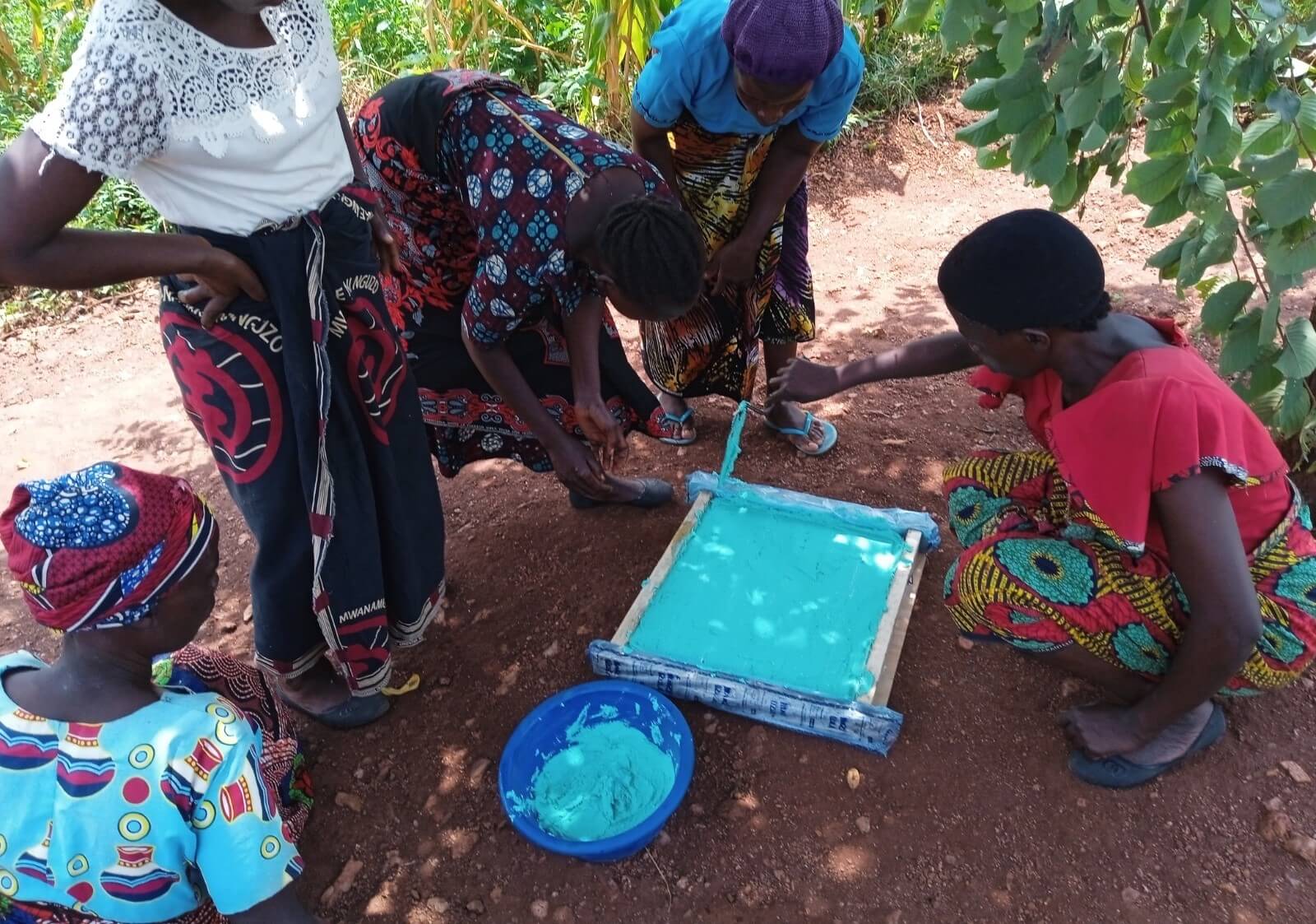 Judith and the group pouring soap into moulds which are later cut and sold.