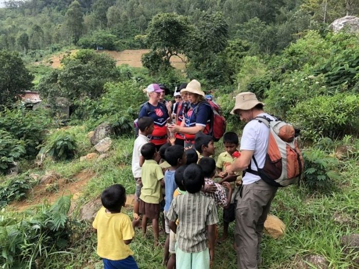Trekkers handing out biscuits to the local kids in Sri Lanka