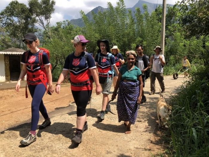 Trekkers walking with locals in a Sri Lankan village