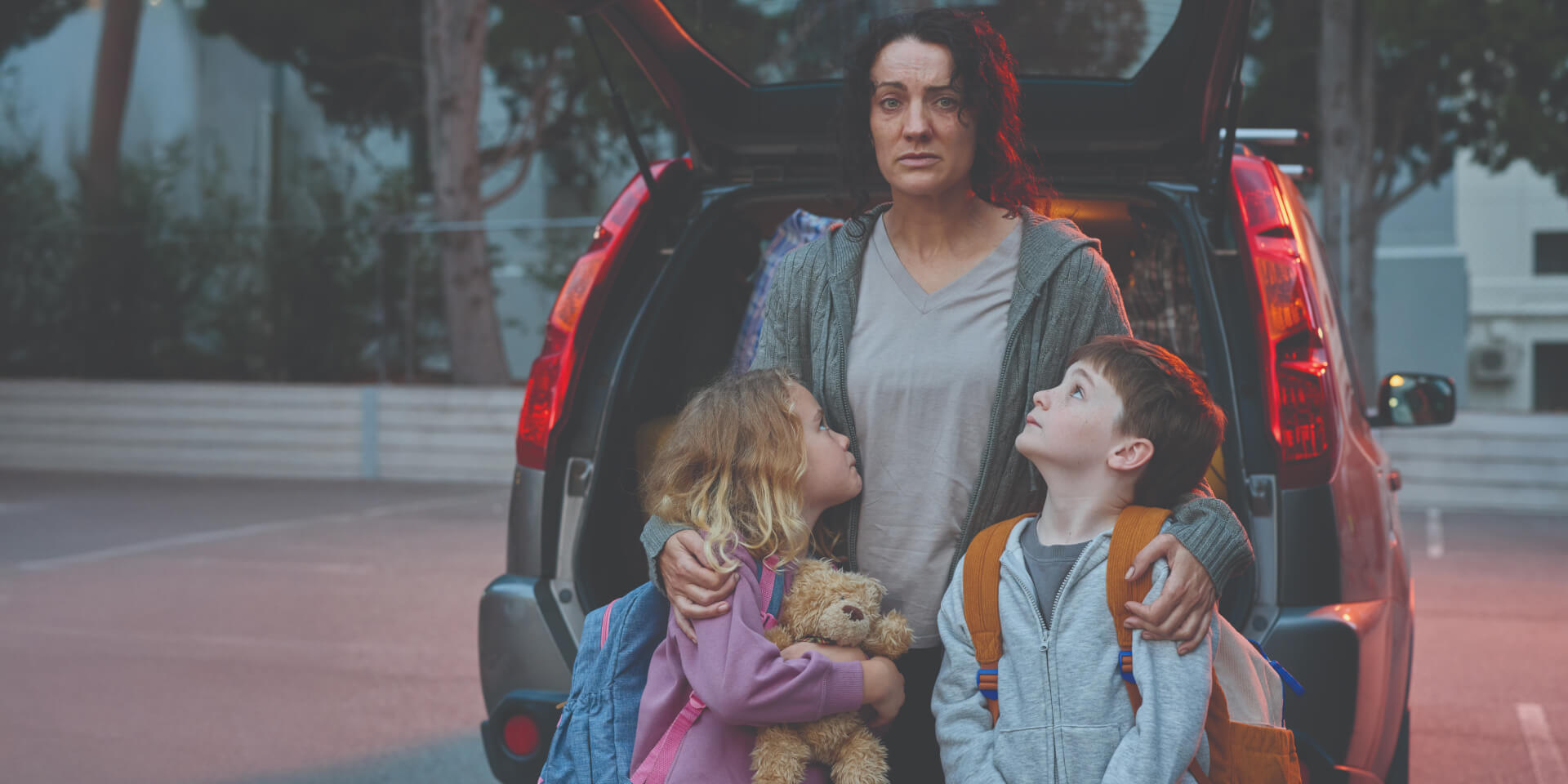 Suzi and her two children looking distressed, wondering where they will sleep for the night