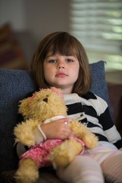 Child looking sad with a teddy bear 