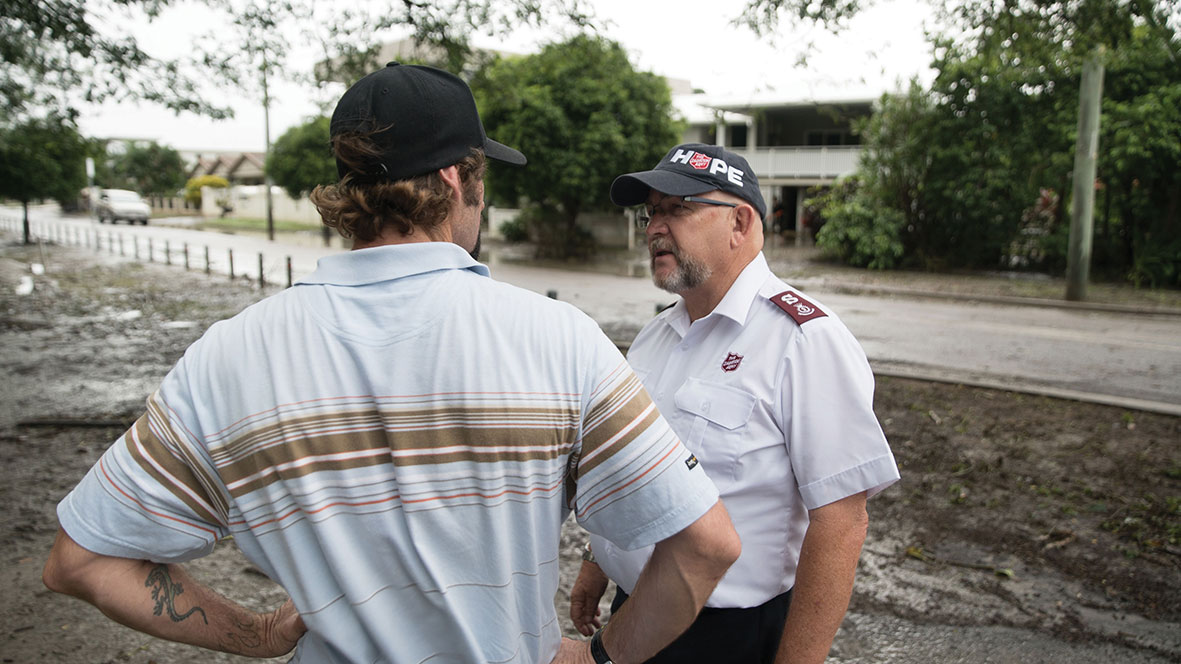 Salvation Army officer speaking to local community member during floods