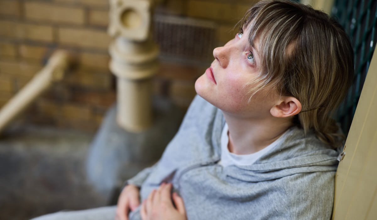 Emily sitting on the floor and looking up to the sky, distressed