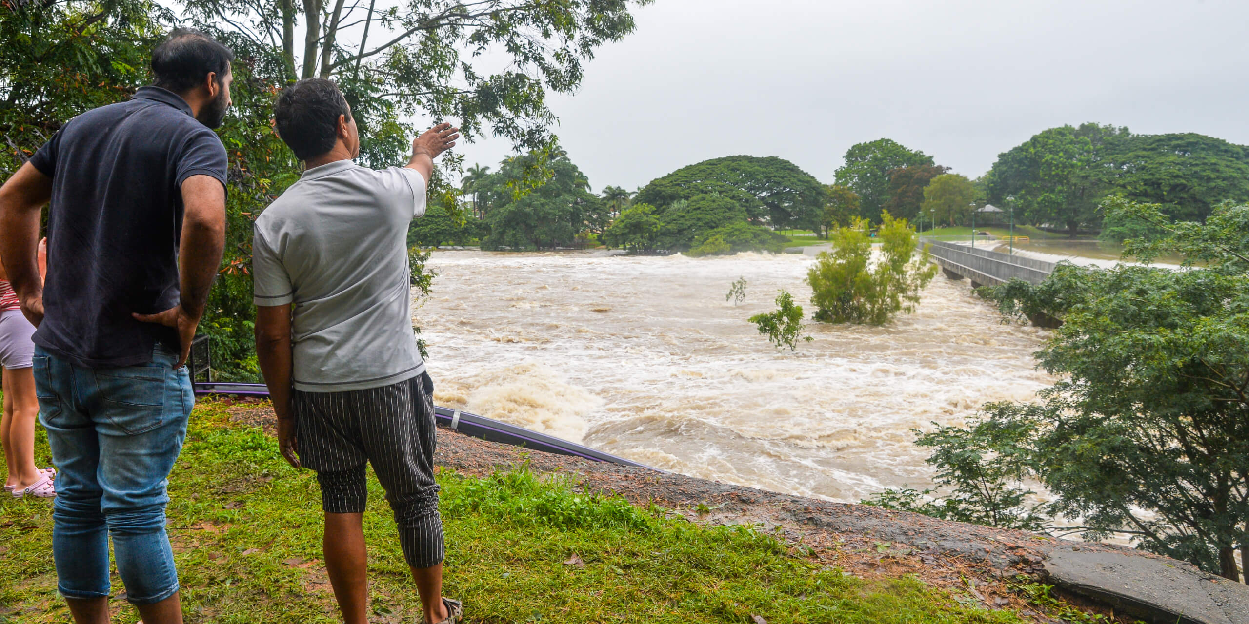 People looking on at flood waters.