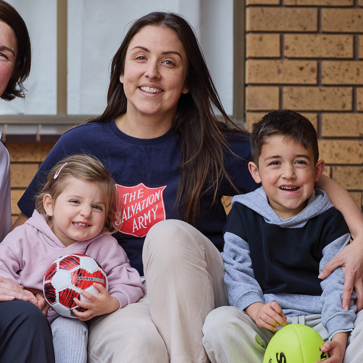 Sophie watches Taylor opening Christmas presents with a Salvos Officer.