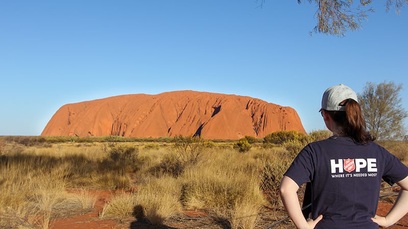 A Salvos volunteer look out towards Uluru