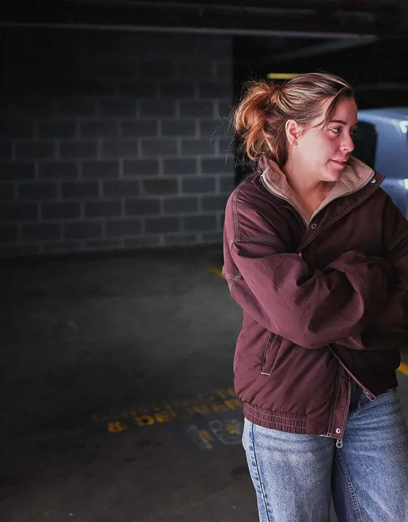 A young woman talks with a Salvos volunteer beside her car.