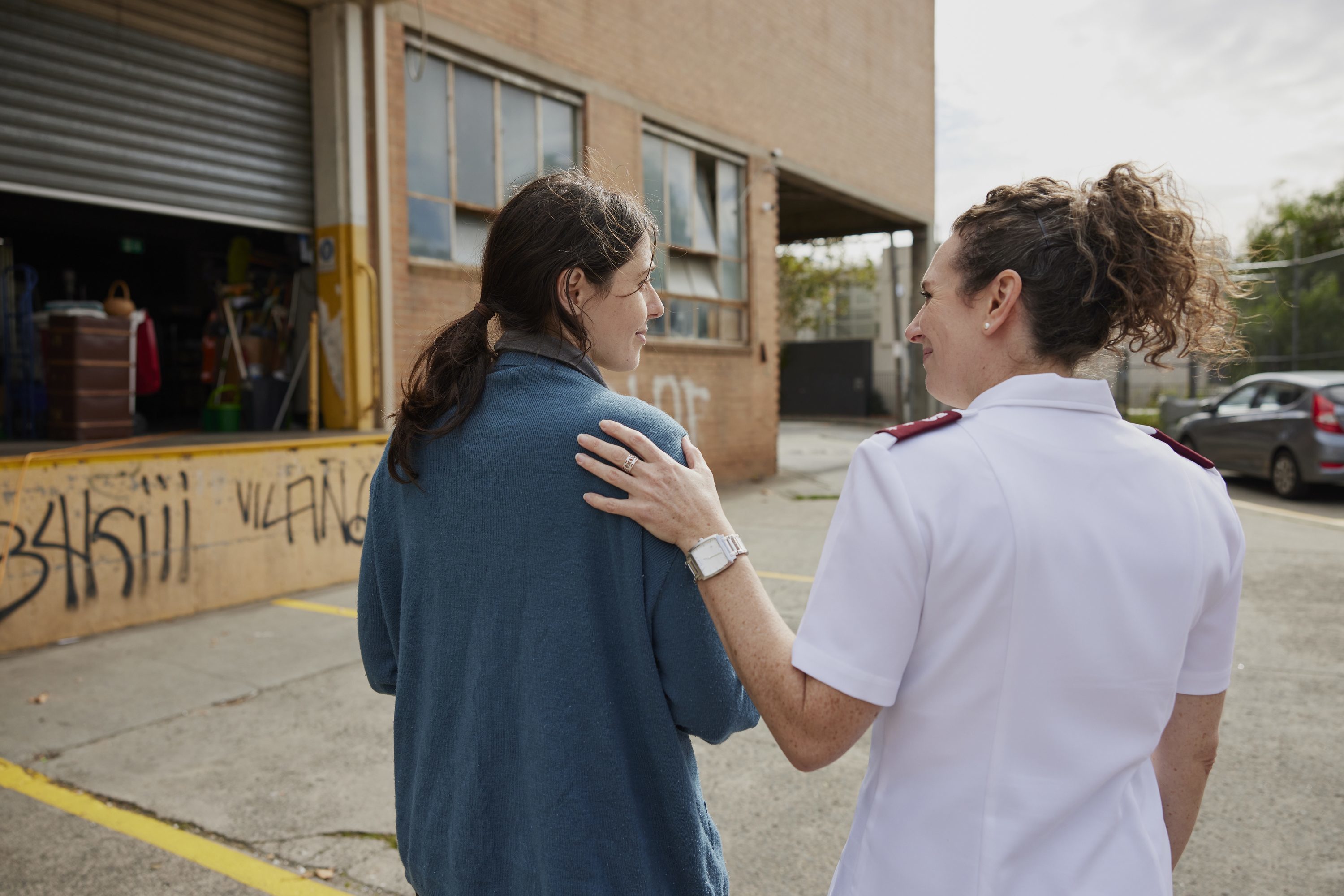 Salvation Army woman with hand on young woman's shoulder