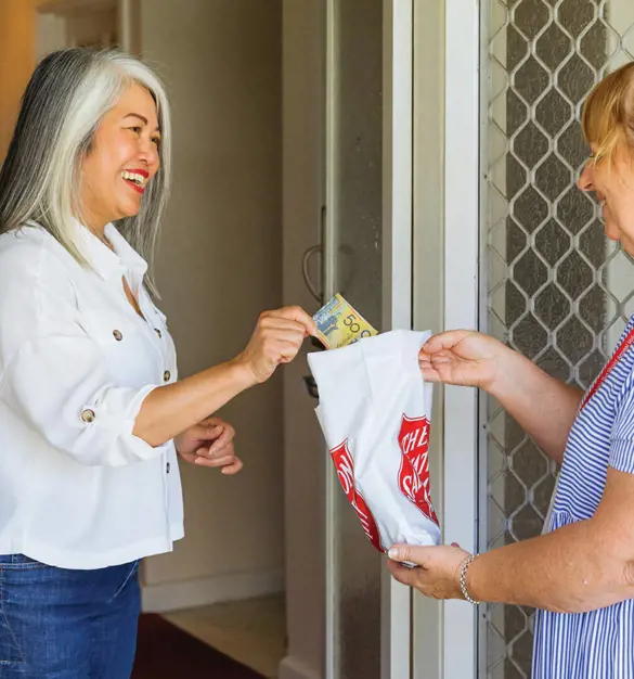A Salvos doorknock volunteer gratefully accepts another donation.