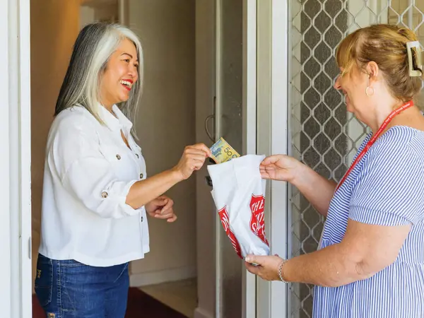A Salvos doorknock volunteer gratefully accepts another donation.