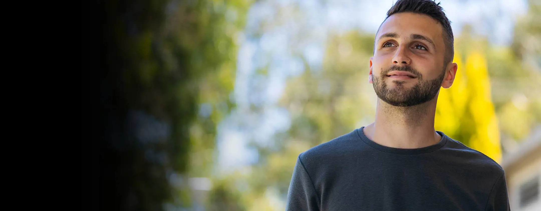 A young man looks optimistically toward the light.