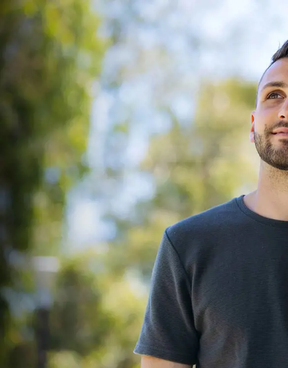 A young man looks optimistically toward the light.