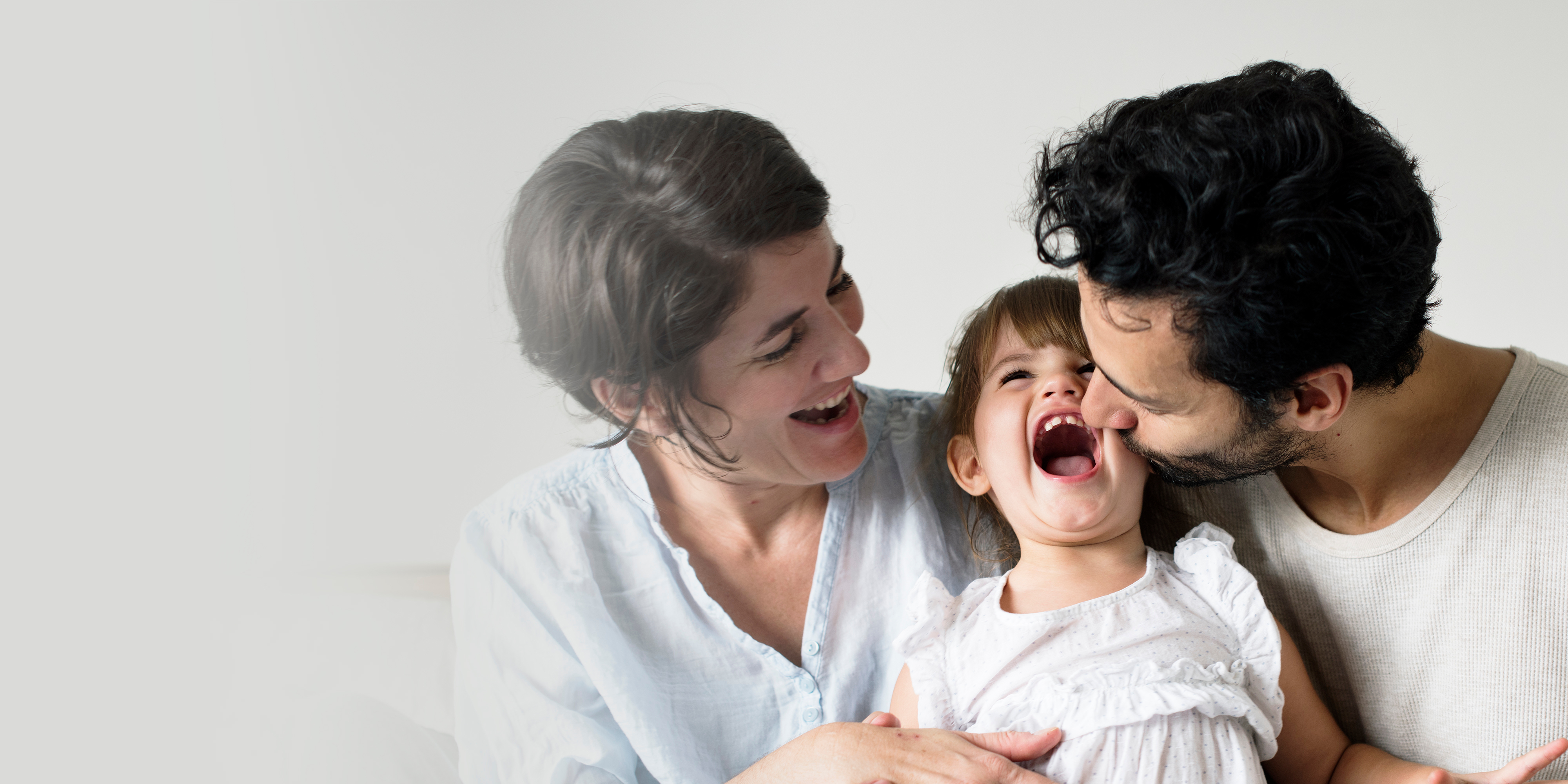 Happy parents laughing with their child