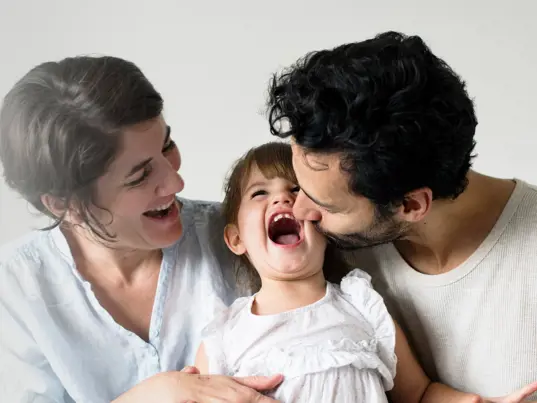Happy parents laughing with their child