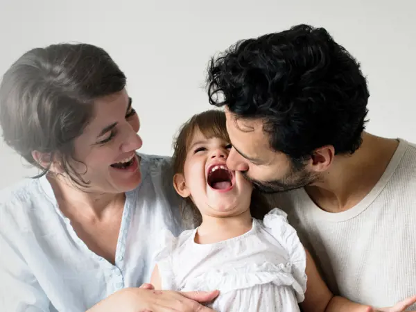Happy parents laughing with their child