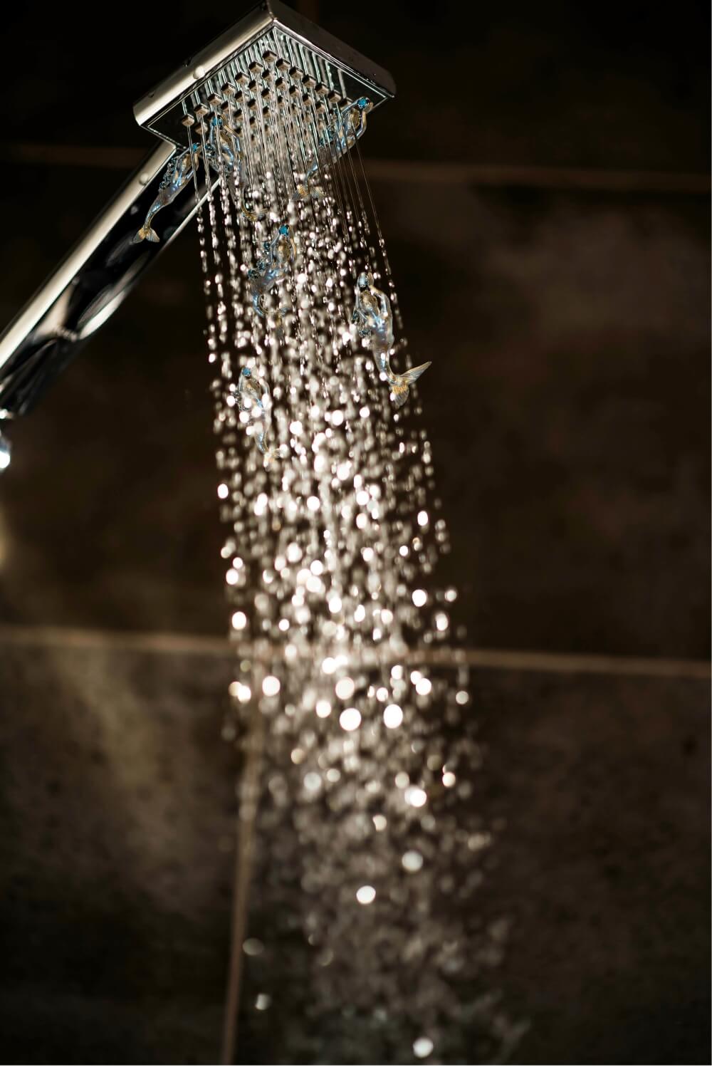 Close up of a shower head with streaming water.