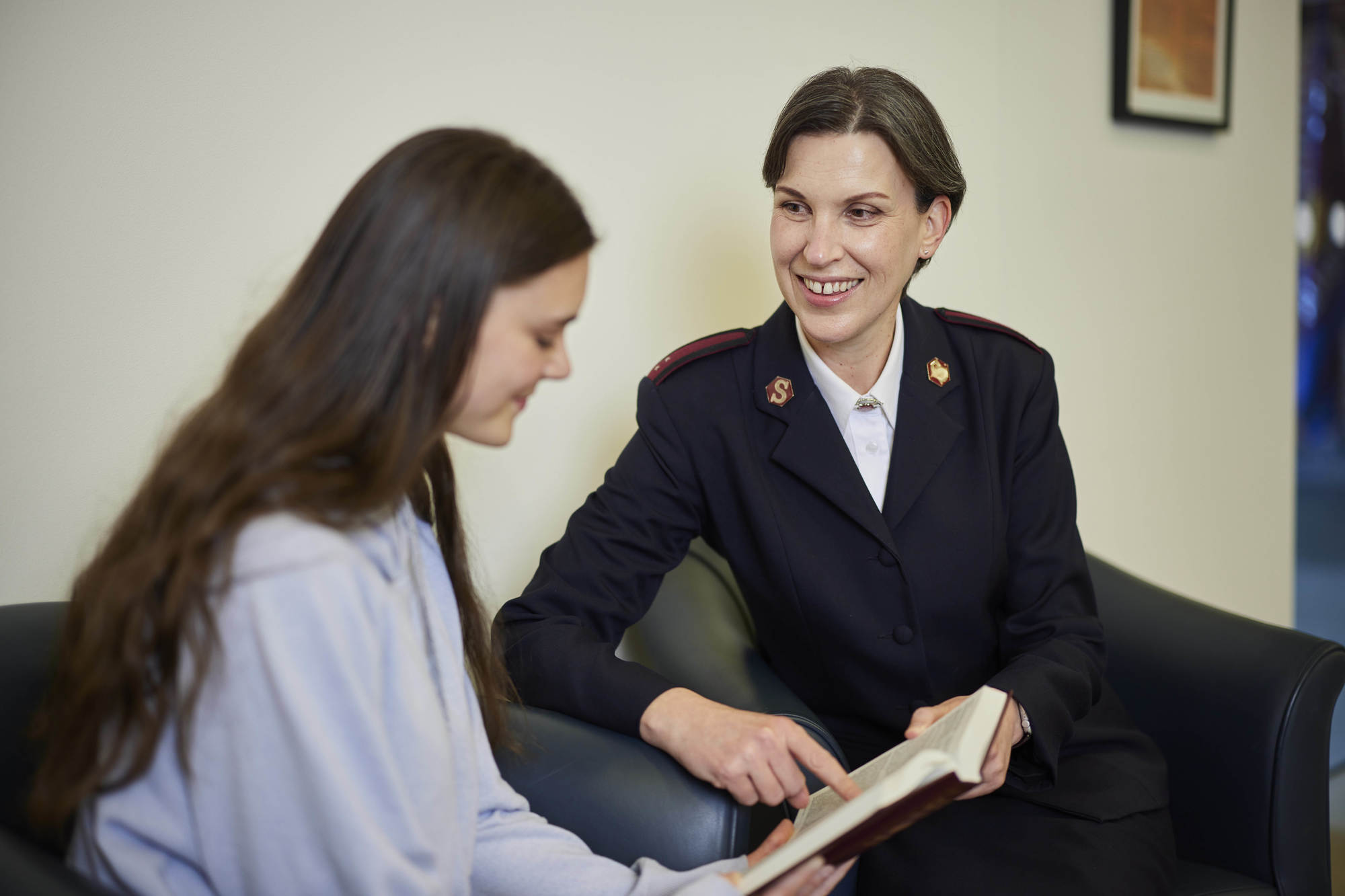 Officer reading with a young woman