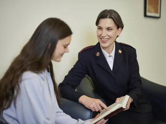 Officer reading with a young woman