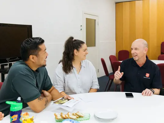 Salvos team member chatting with a young family