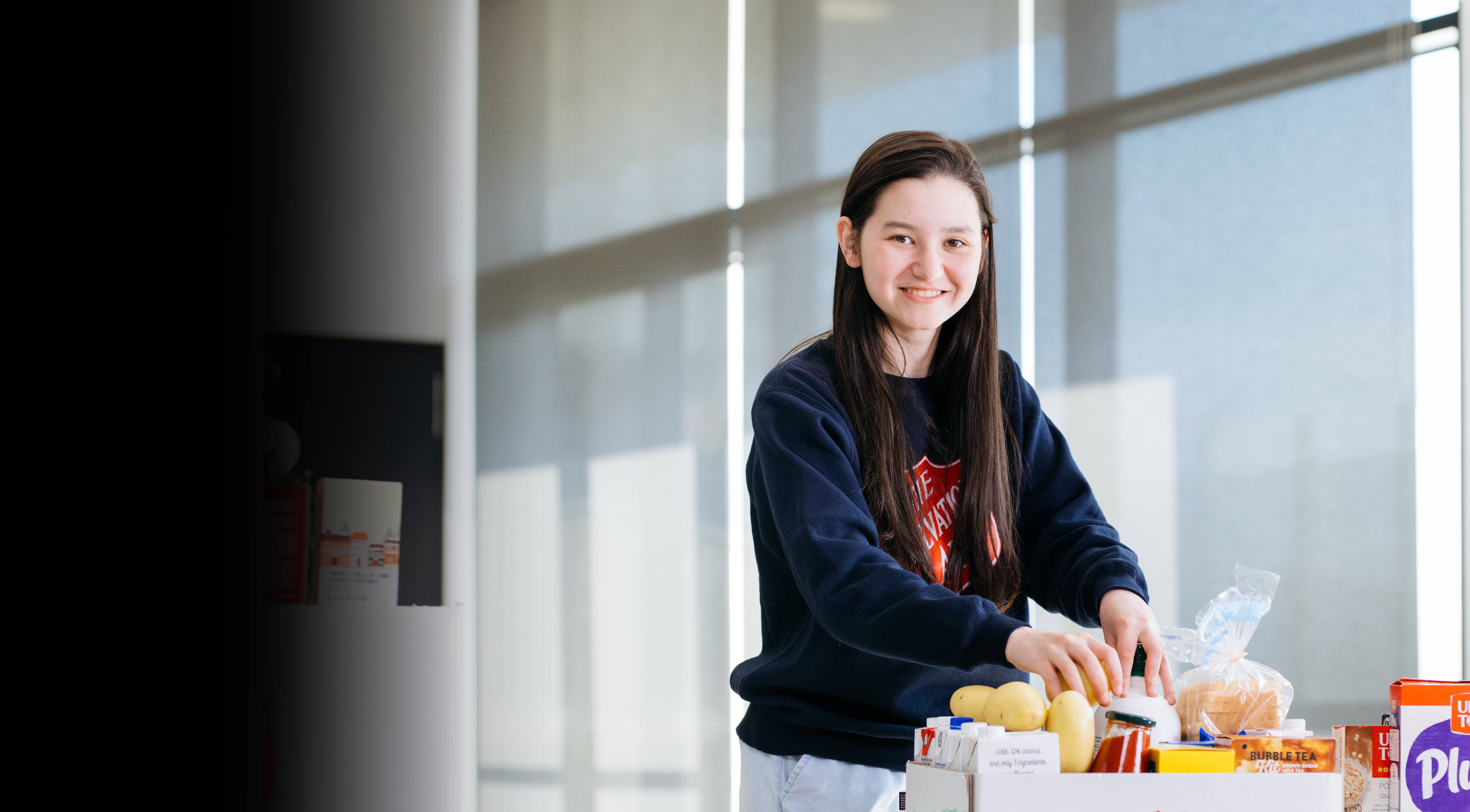 A Salvos volunteer unpacking a box of food. 
