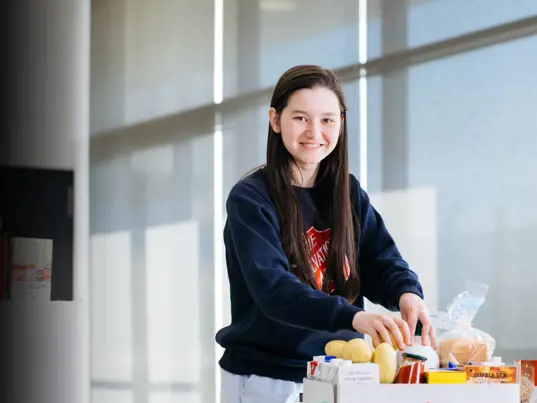 A Salvos volunteer unpacking a box of food.