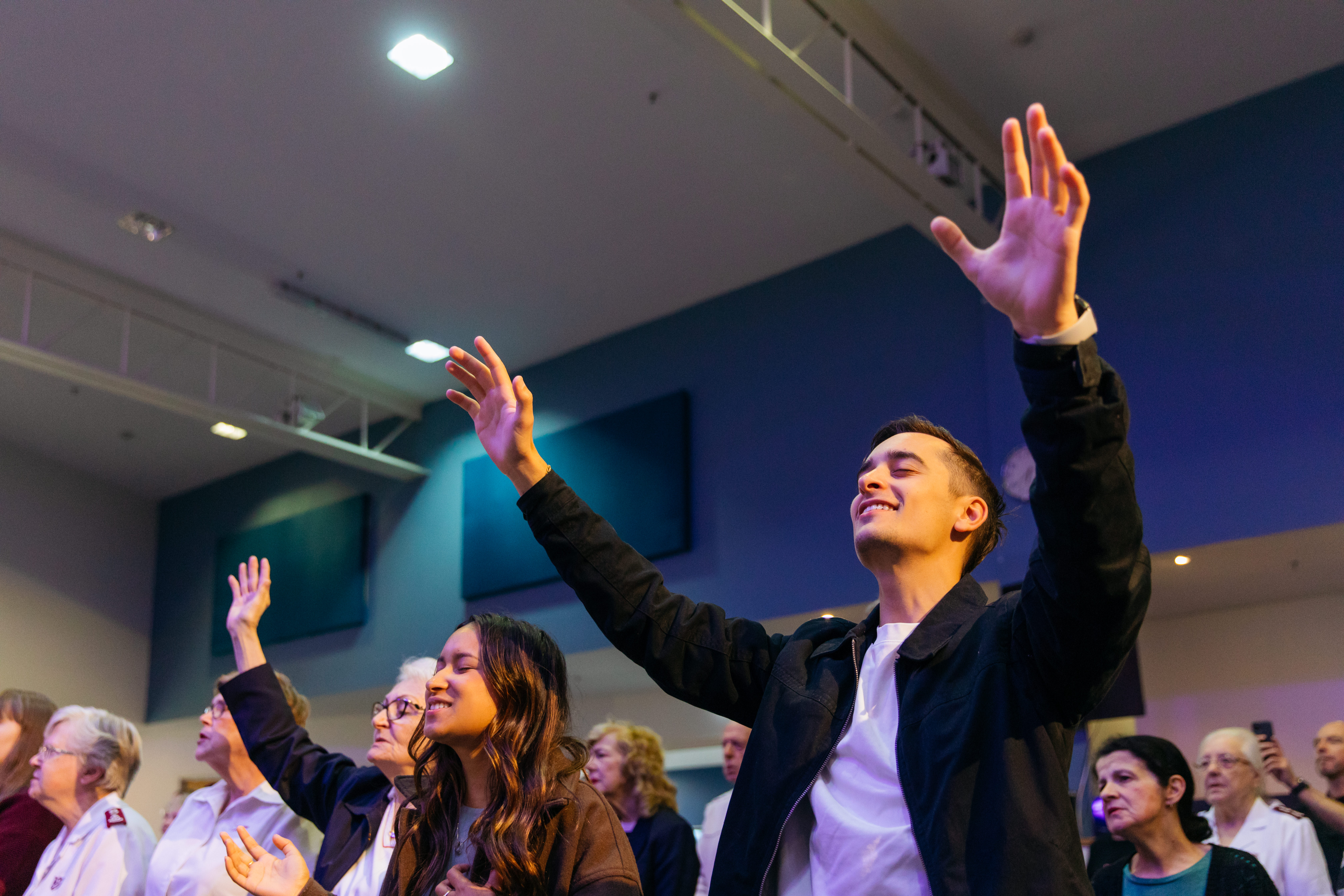 People with arms open worshipping during a service
