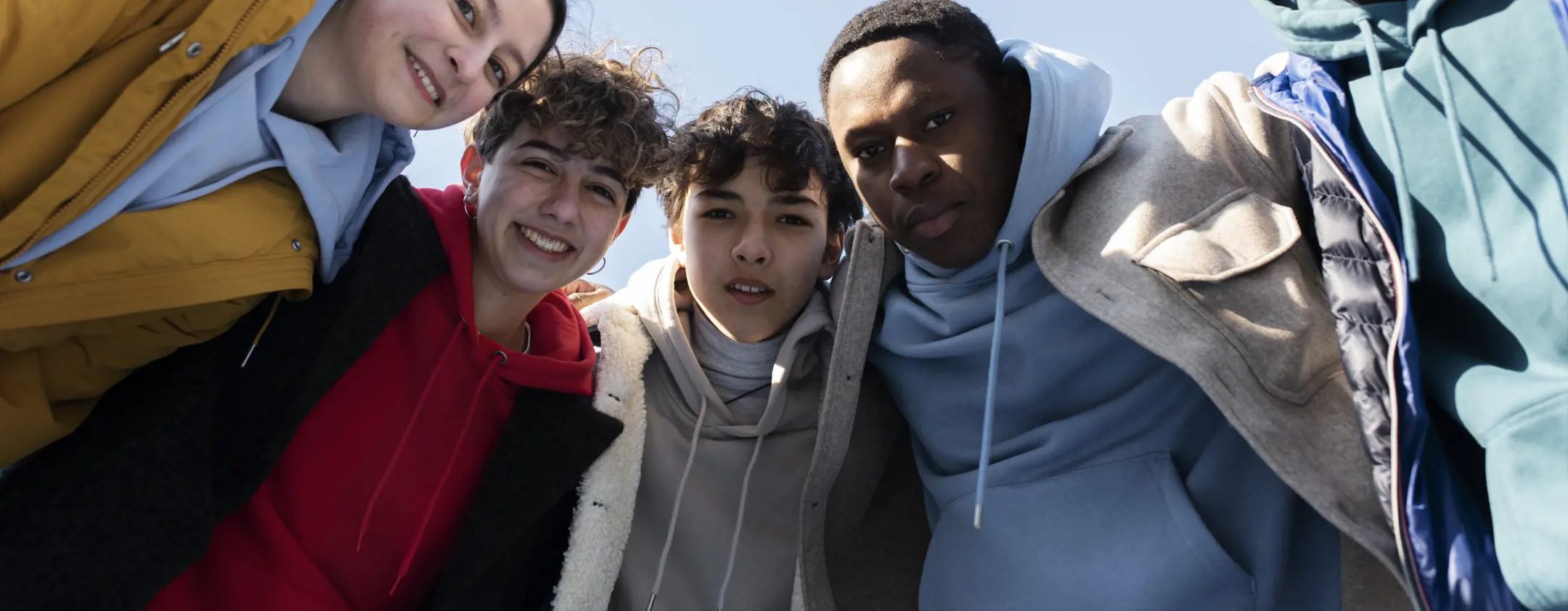 A group of young adults laughing and spending time together outdoors.