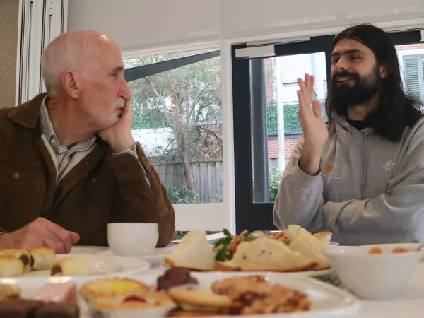 Two men sitting chatting together over morning tea