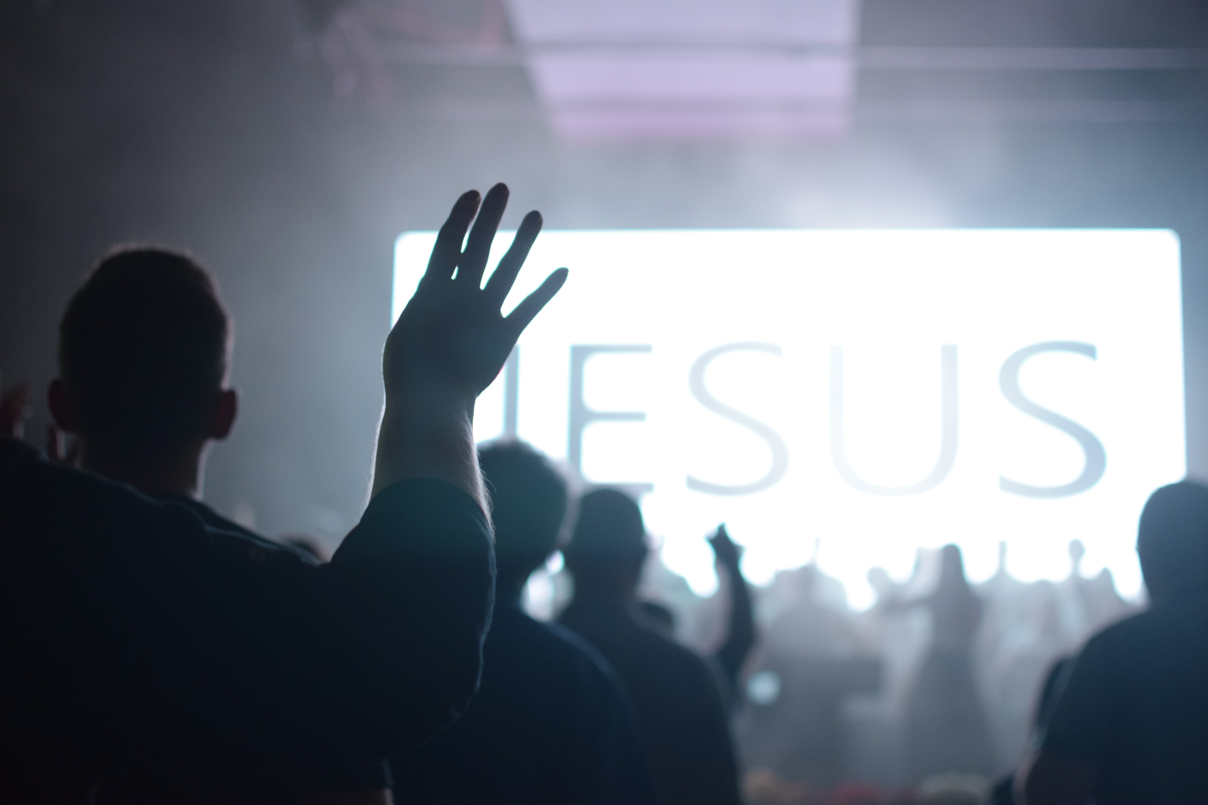 A crowd of people worshipping at church. 