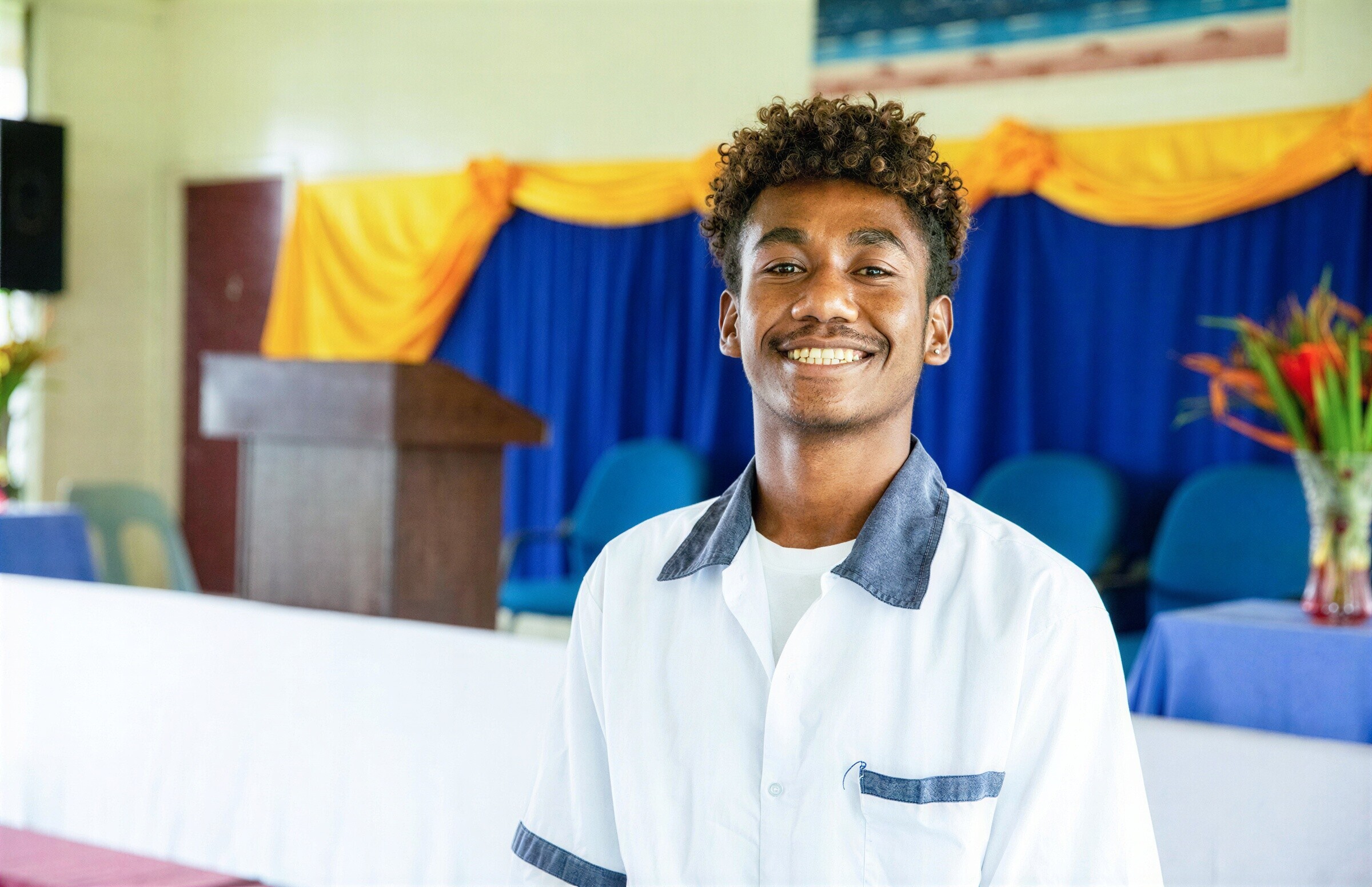 A young man smiles warmly