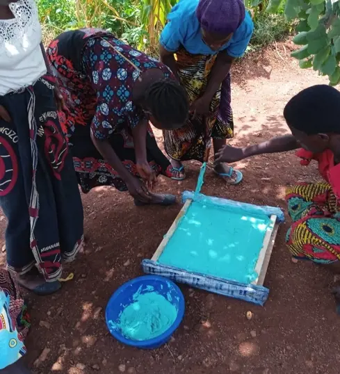 Judith and the group pouring soap into moulds which are later cut and sold.
