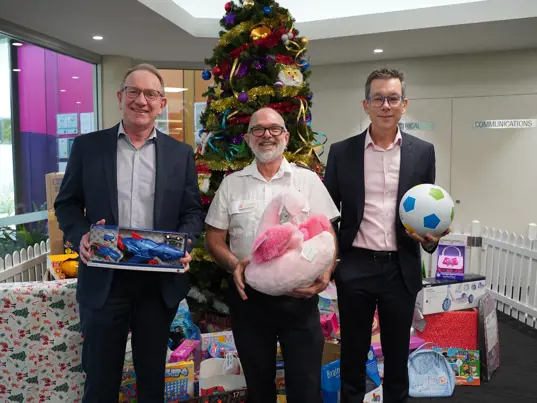 Men at Logan Salvation Army holding Christmas presents