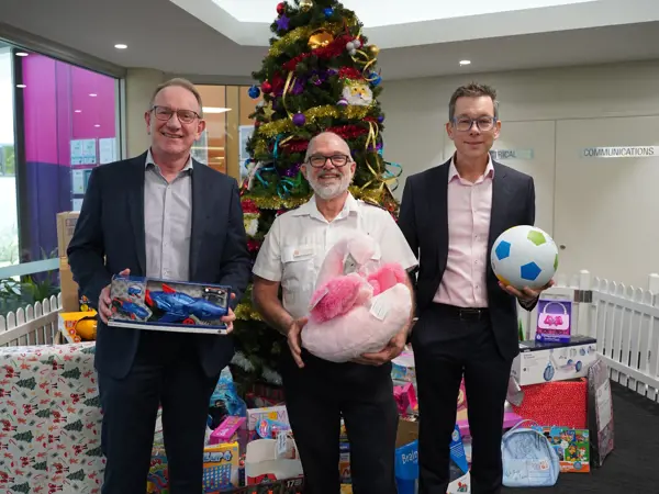 Men at Logan Salvation Army holding Christmas presents
