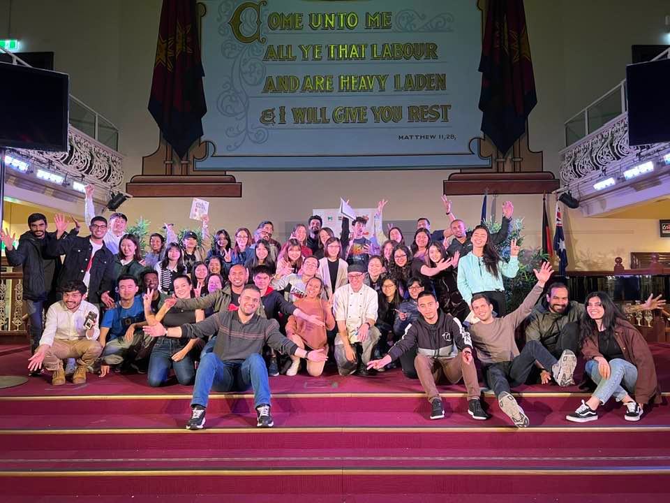 Group of people posing for the camera in the main auditorium