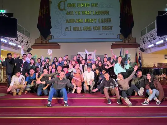 Group of people posing for the camera in the main auditorium