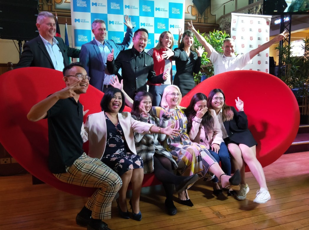 Group of people posing on a couch for a photo