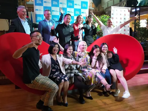 Group of people posing on a couch for a photo