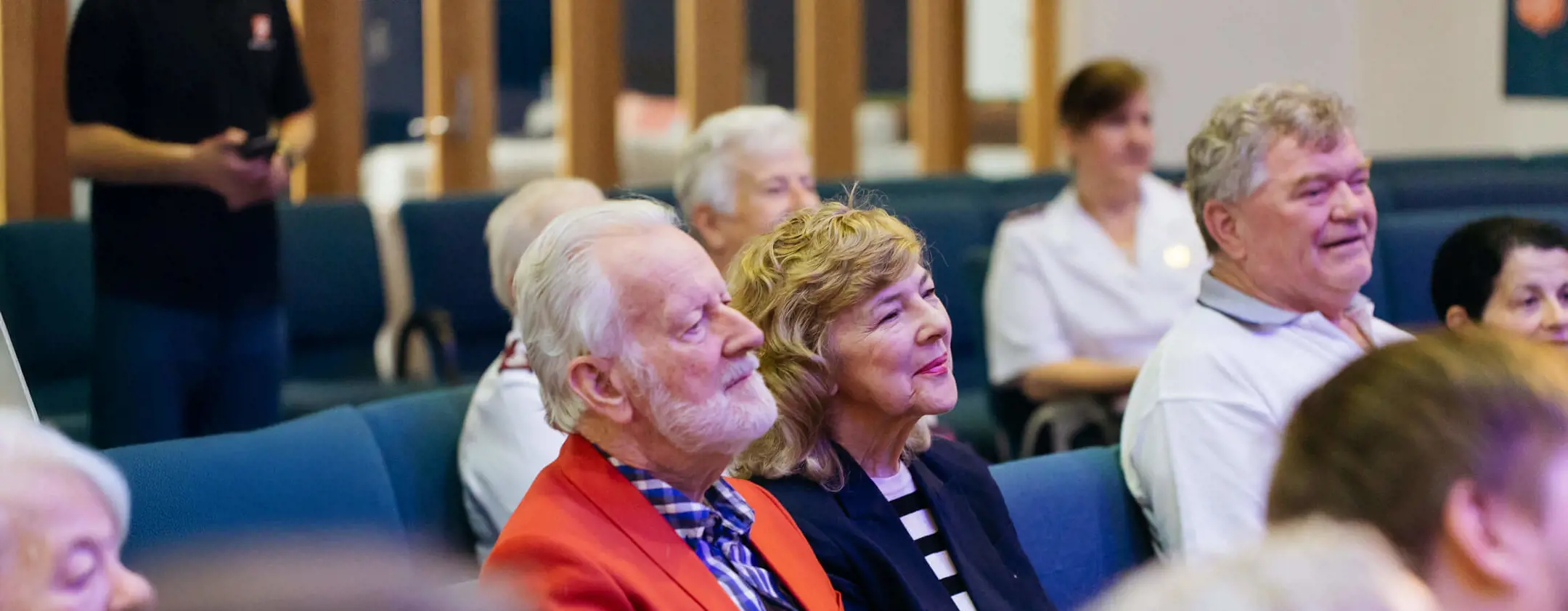 A Salvos crowd of a gathering sitting and watching an event