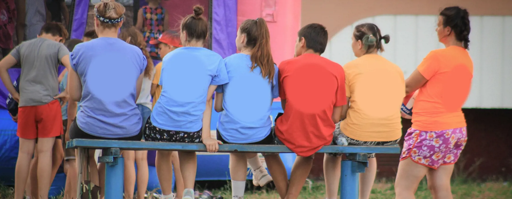 Rear view of a group of teenagers sitting together.