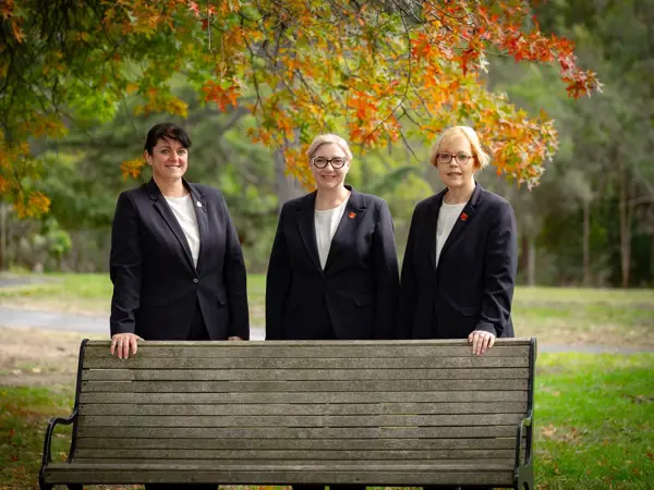 Three members of the Salvos Funerals team standing together outdoors