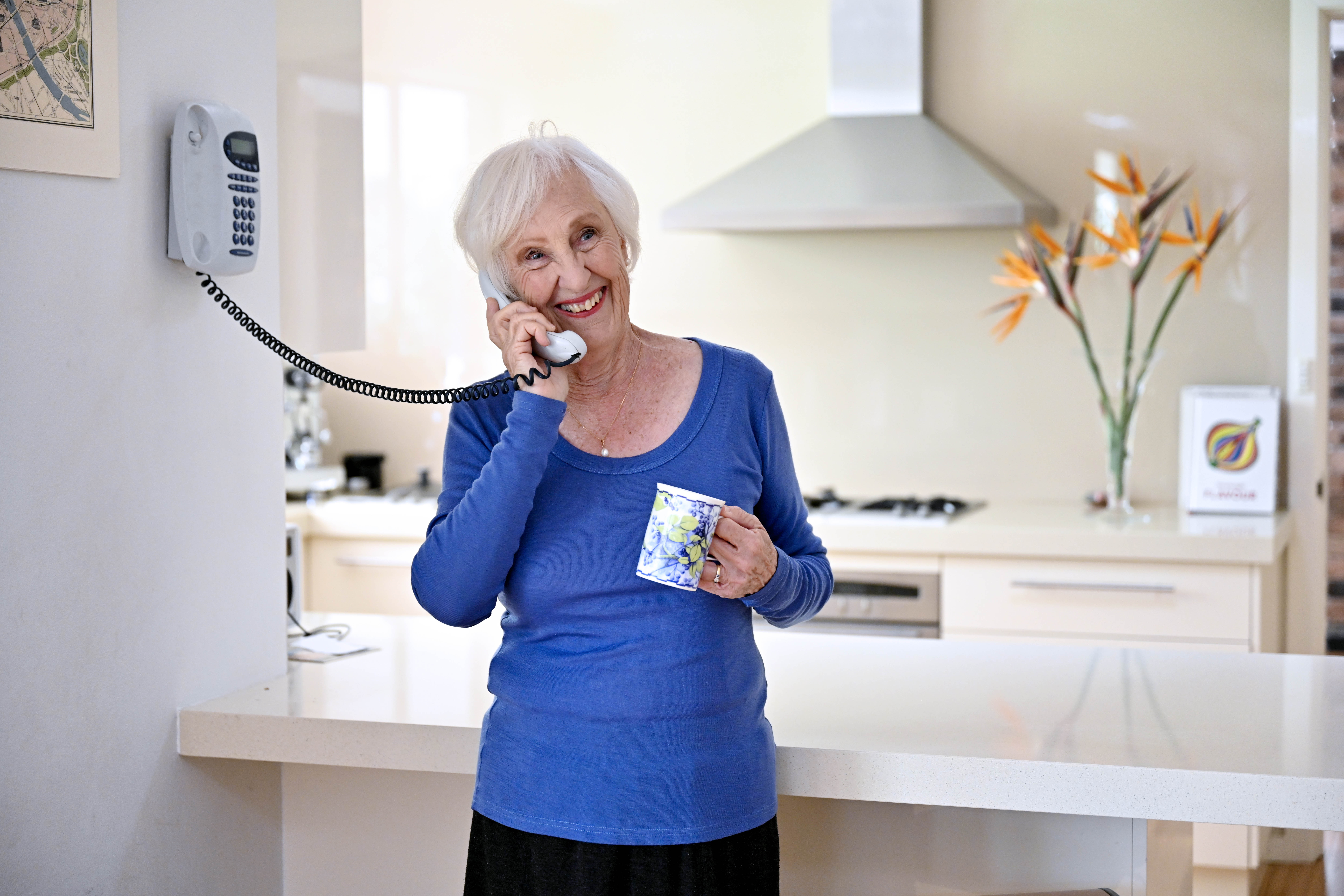 Older woman speaking on the phone at home