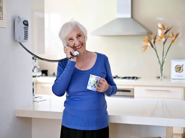 Older woman speaking on the phone at home