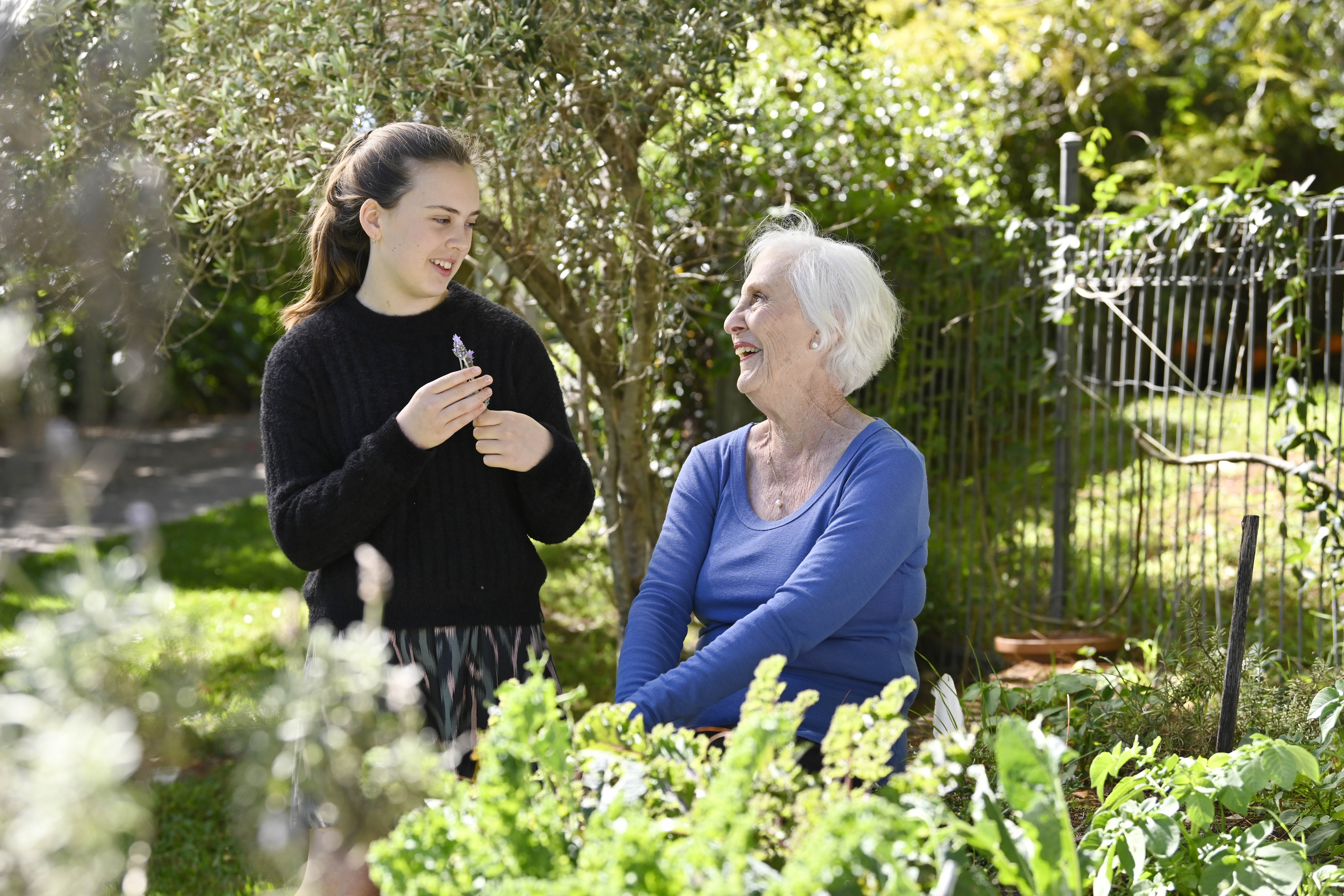 Grandmother and granddaughter talking together in a garden