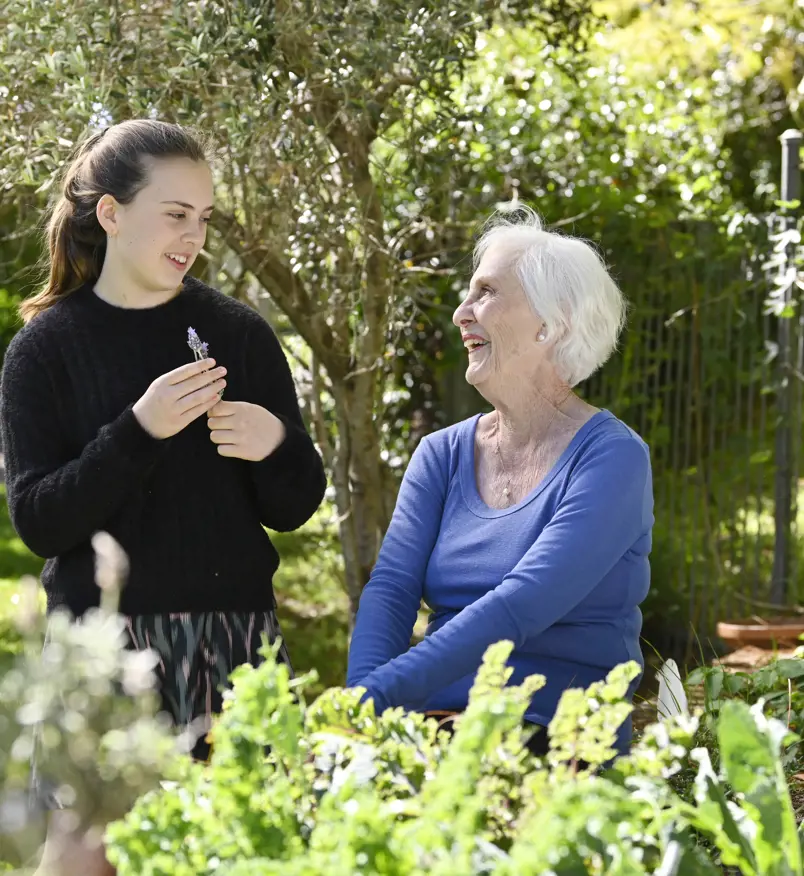 Grandmother and granddaughter talking together in a garden