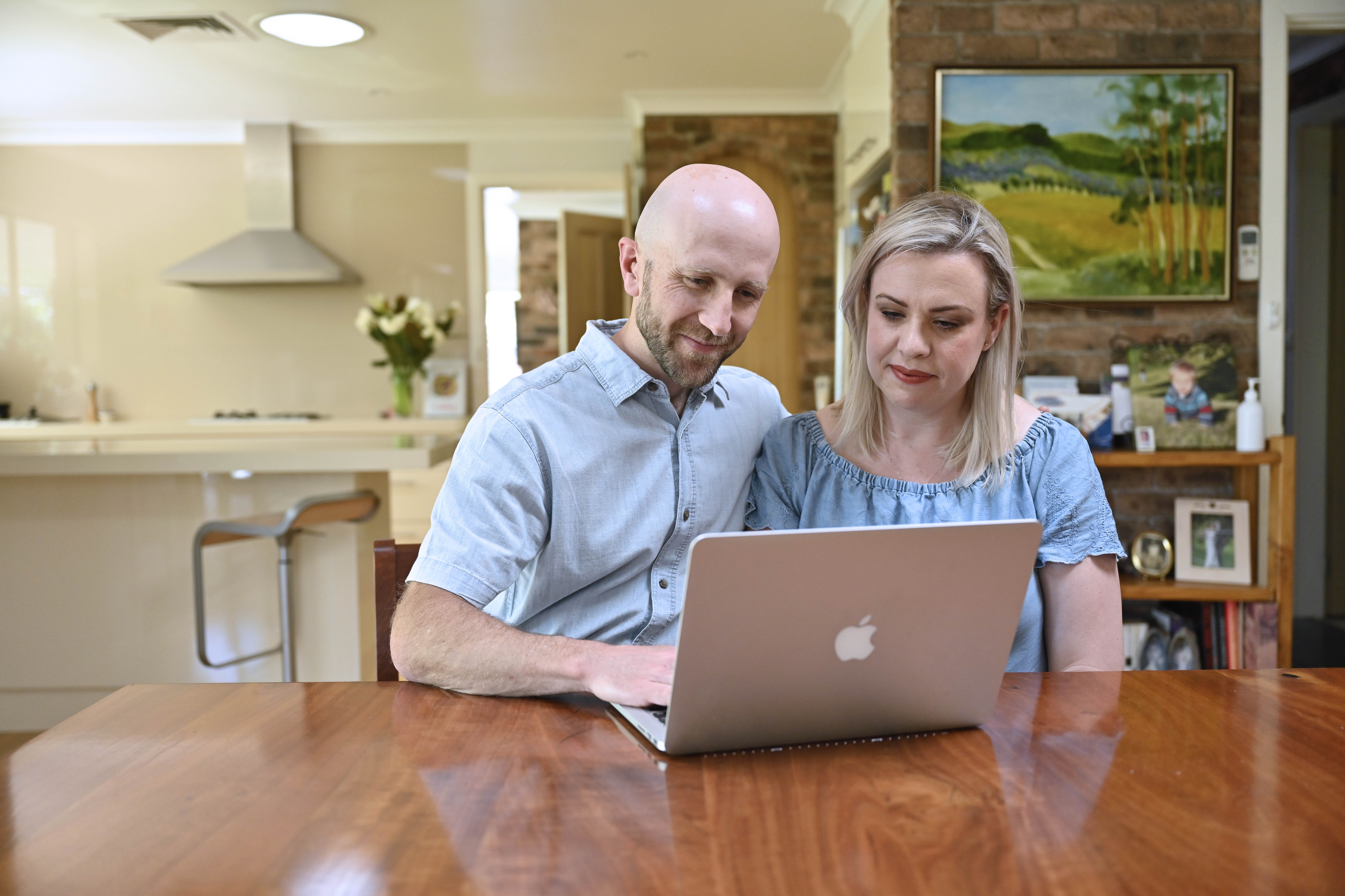 Couple reviewing information together on a laptop at home