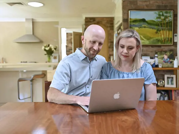 Couple reviewing information together on a laptop at home